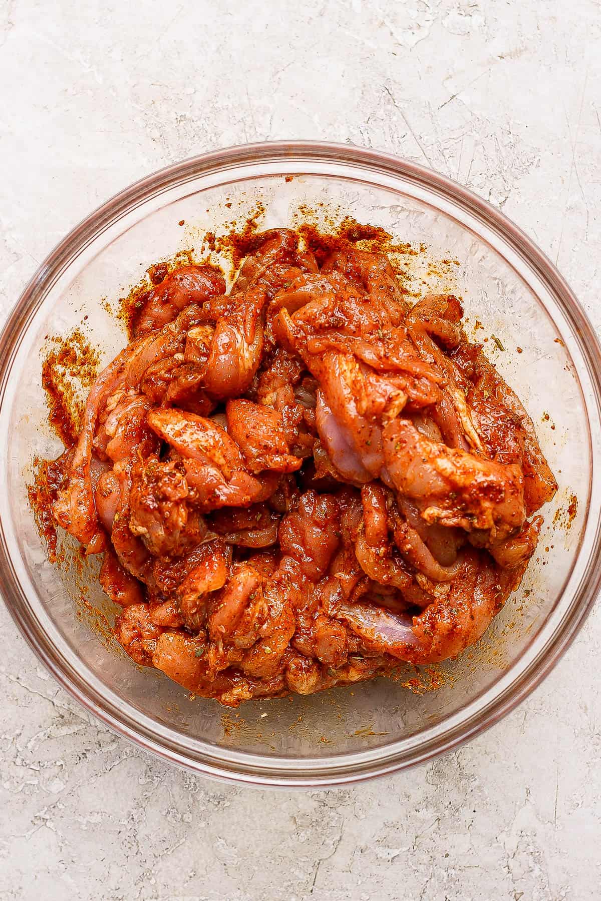 Strips of chicken thighs tossed in fajita seasoning, oil, and lime juice before being baked on a sheet pan.
