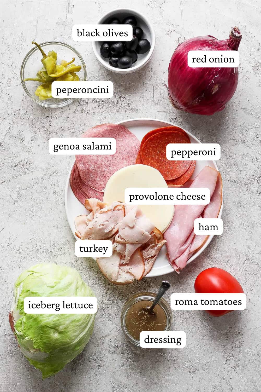 Ingredients for an Italian sub in a tub in separate bowls and plates with labels.