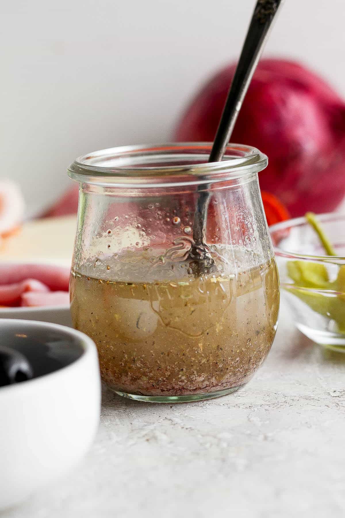 Vinaigrette dressing for a Sub in a Tub in a small glass jar with a spoon sticking out the top.