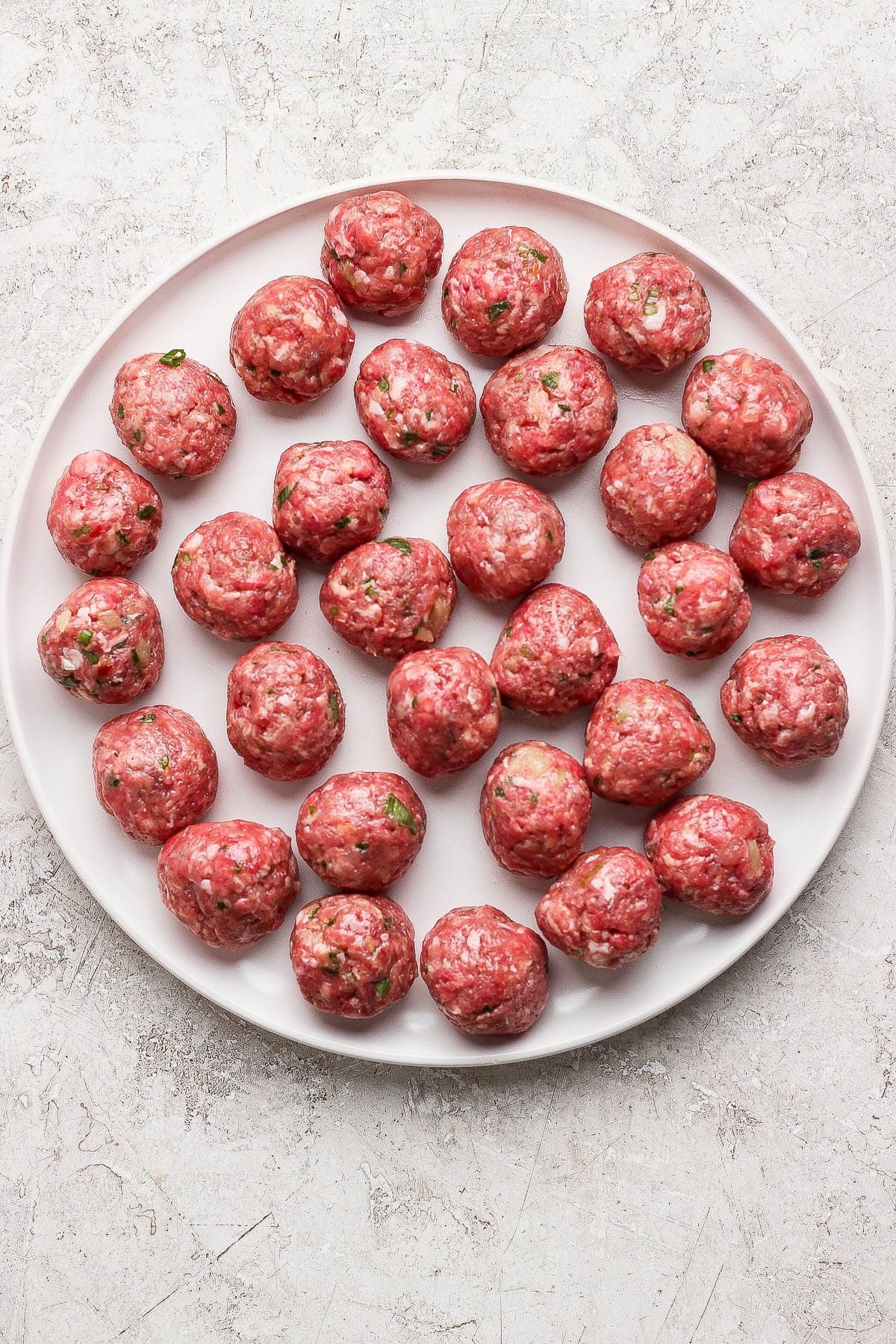 Raw pineapple teriyaki meatballs on a plate.