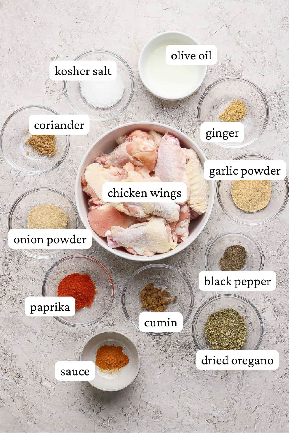 Ingredients for chicken wings on the blackstone in separate bowls with labels.