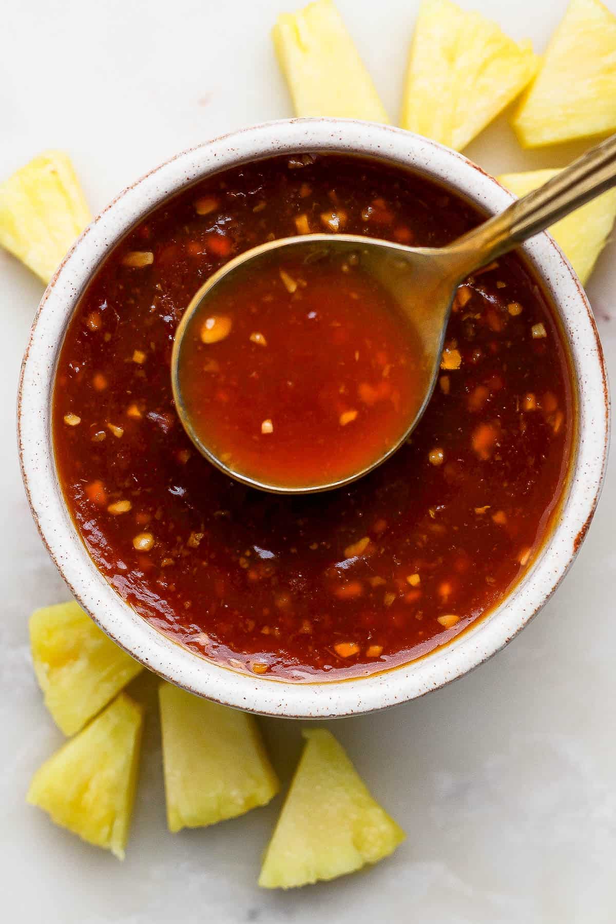 Pineapple teriyaki sauce in a bowl with a spoon.