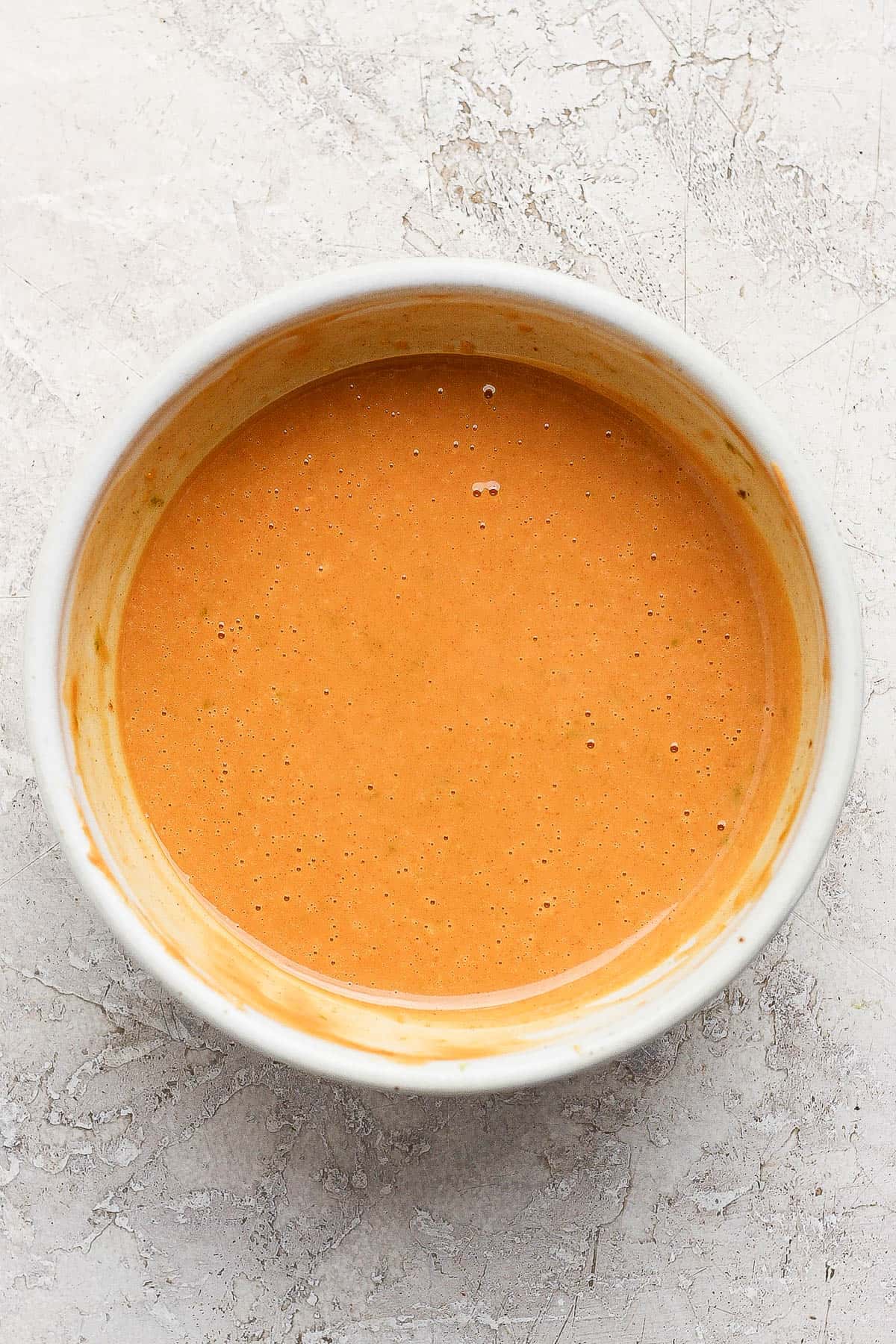 The homemade peanut dressing for a Thai peanut rotisserie chicken salad in a small bowl.