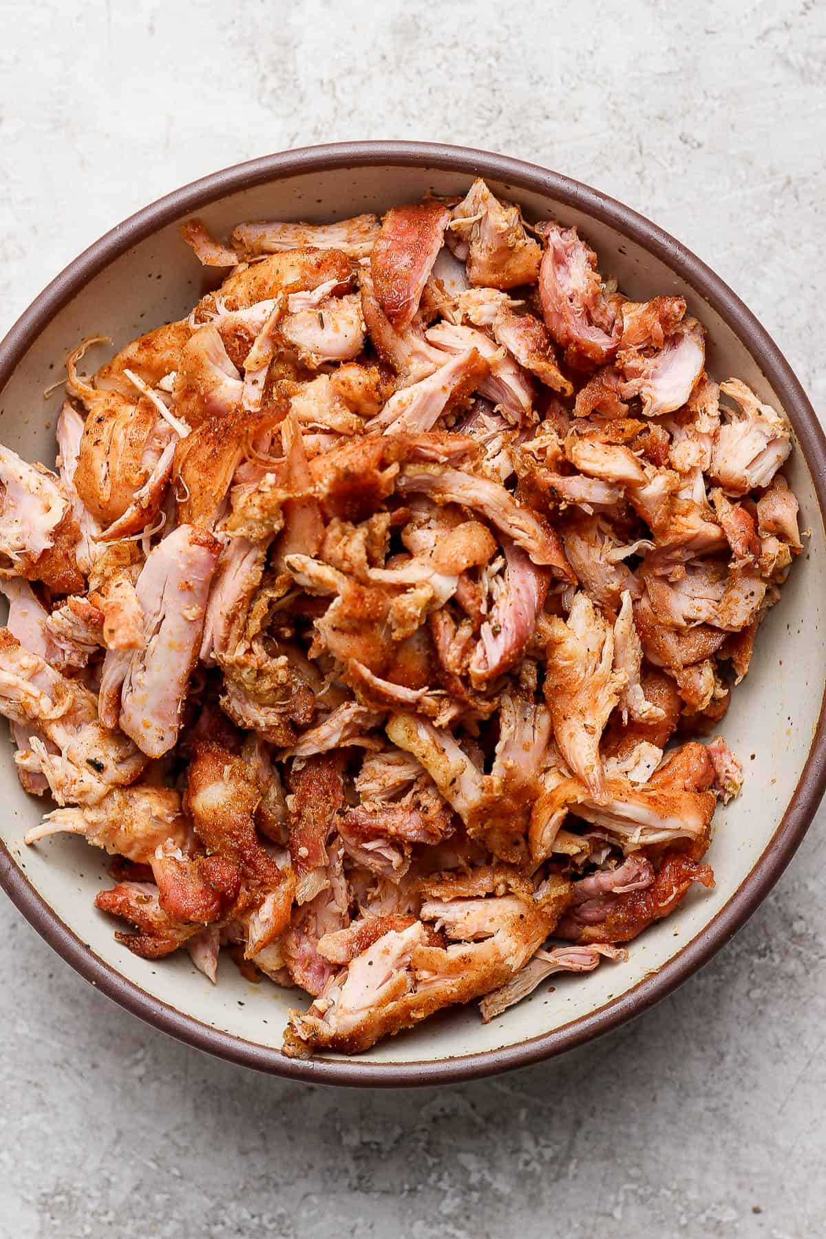 Shredded rotisserie chicken in a bowl before being added to a rotisserie chicken salad.