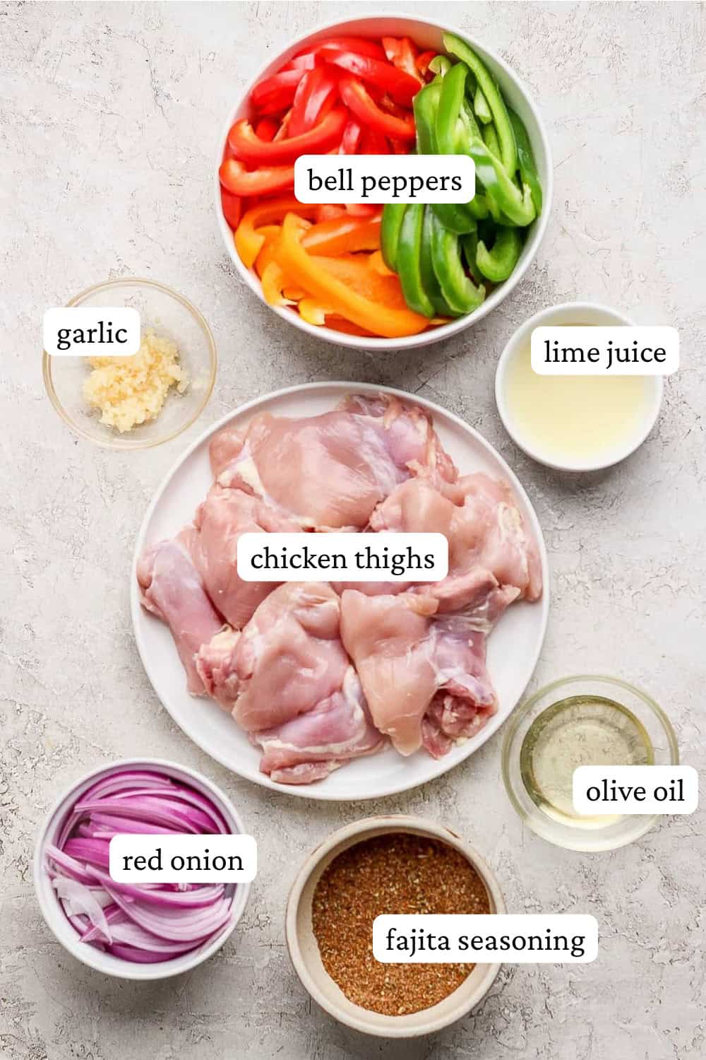 Ingredients for sheet pan chicken fajita bowls in separate bowls with labels.