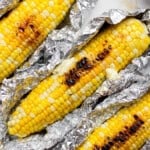 Three ears of Blackstone corn on the cob in aluminum foil.