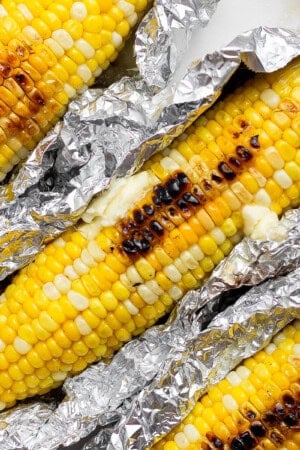 Three ears of Blackstone corn on the cob in aluminum foil.