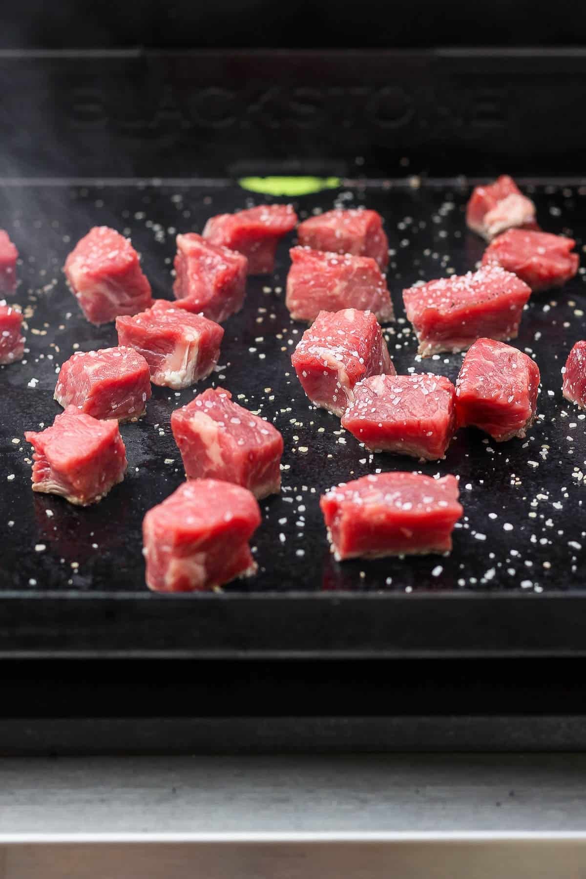 Blackstone steak bites added to a hot flat top griddle.