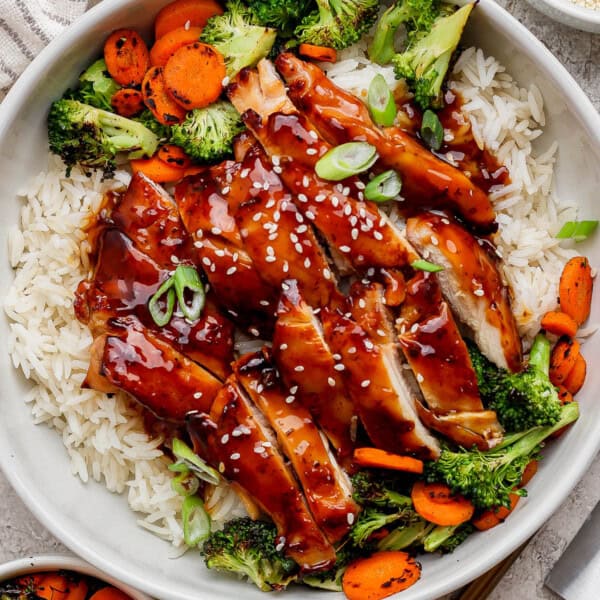 Blackstone teriyaki chicken over rice in a large white bowl.