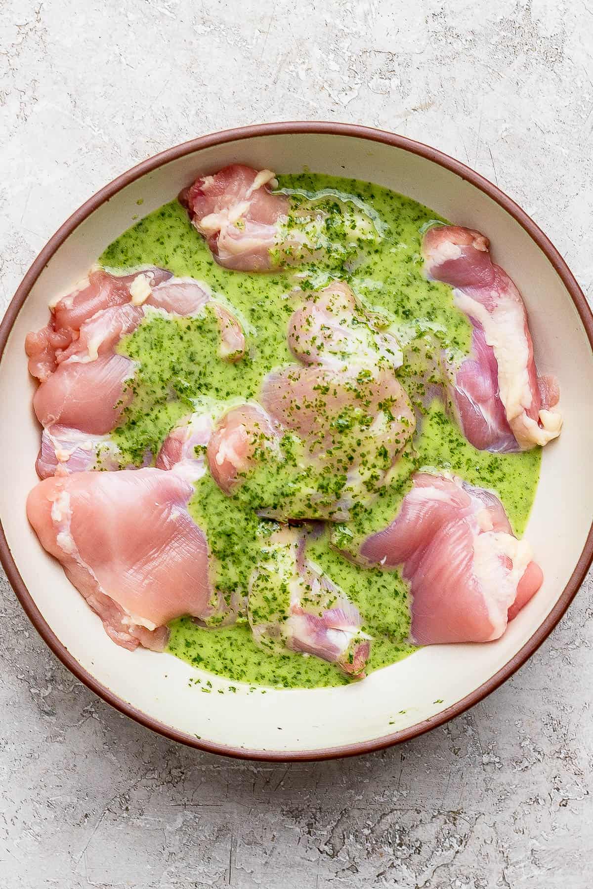 Cilantro lime chicken thighs in a large bowl with the marinade before cooking.