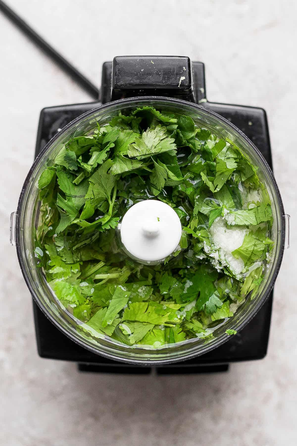 Cilantro lime marinade in a food processor before being blended.