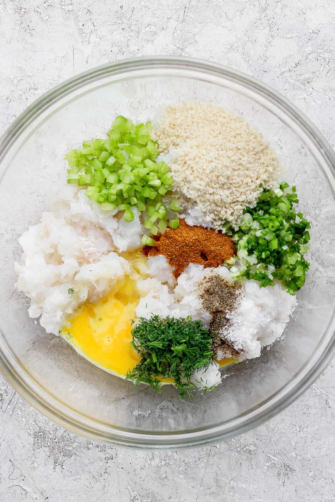 Ingredients for cod cakes in a bowl, unmixed. 