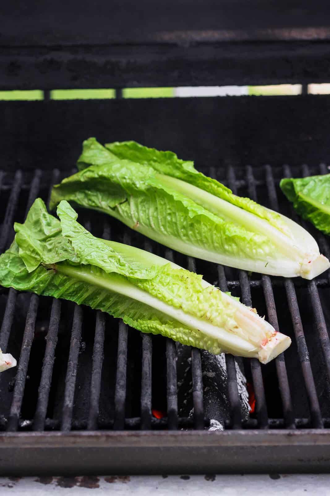 Two romaine halves on the grill, cut side down.