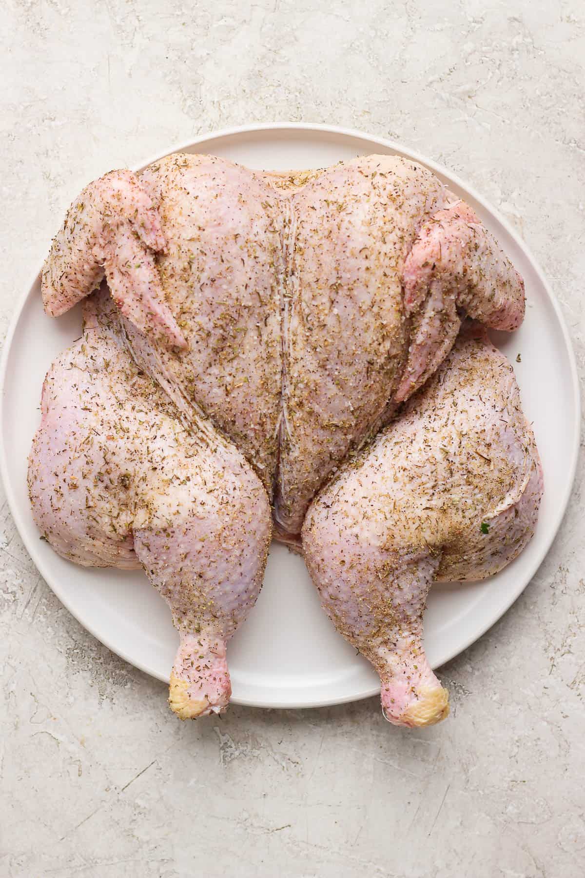 A seasoned spatchcock chicken before going on the grill.