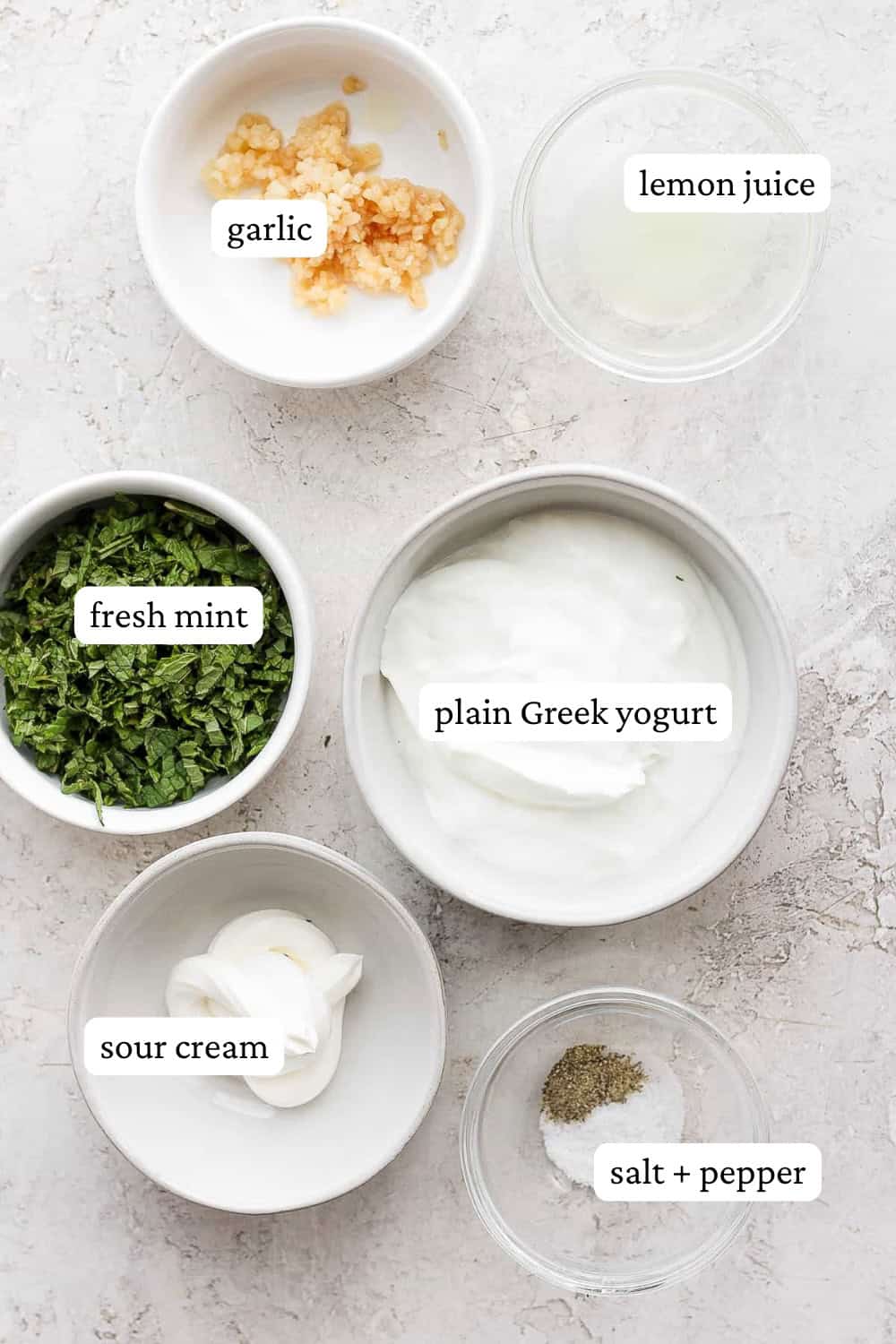 Ingredients for lamb sauce in separate bowls with labels.