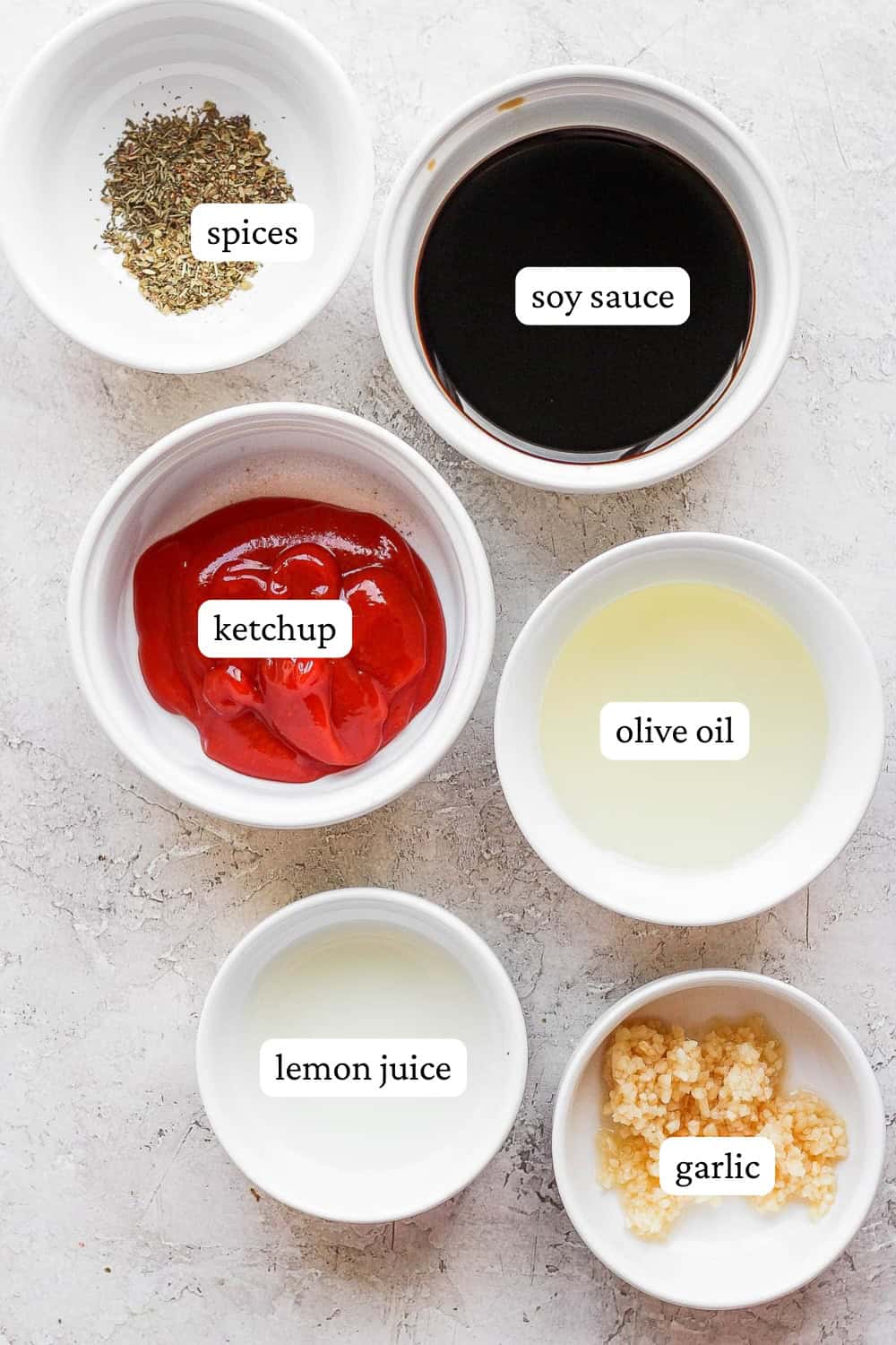 Ingredients for a pork loin marinade in small bowls with labels.