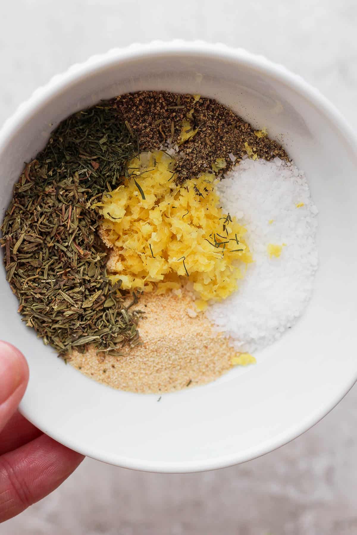 Salmon seasoning ingredients separated in a white bowl.