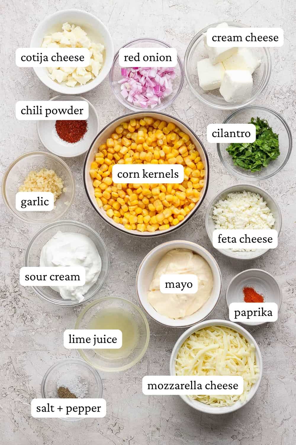 Street corn dip ingredients in separate bowls with labels.