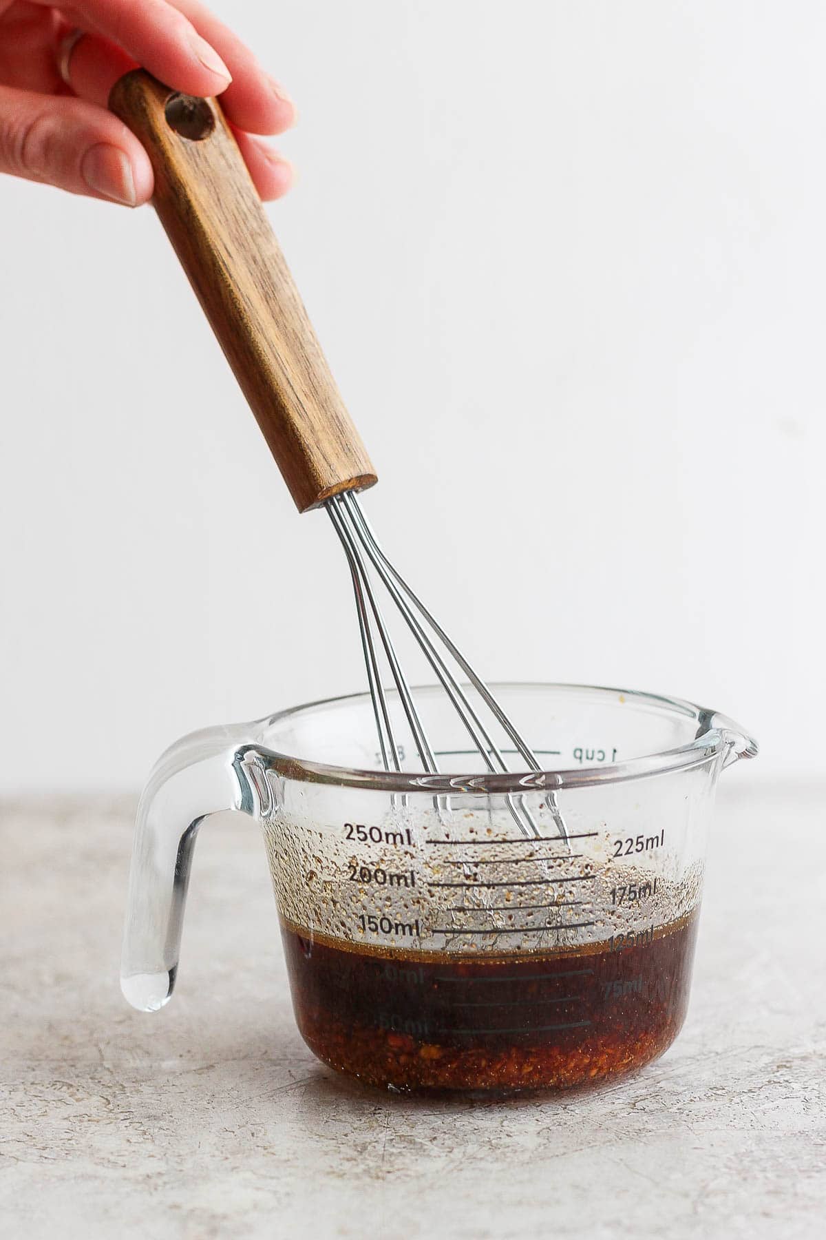 The sauce for veggie lo mein being whisked in a glass measuring cup.
