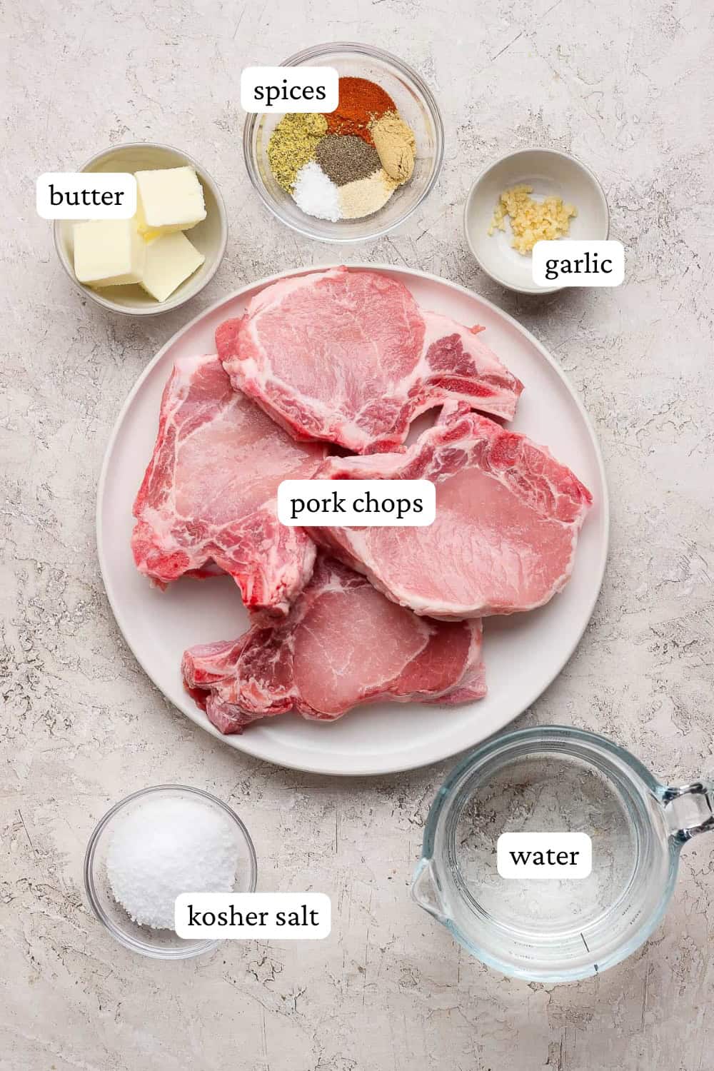 Blackstone pork chops on a plate and in small bowls with labels.