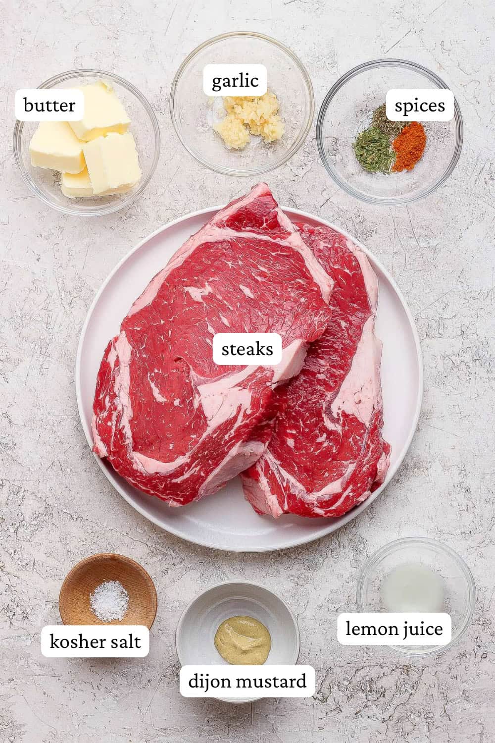 Ingredients for Blackstone steak bites on a plate and in small bowls with labels.