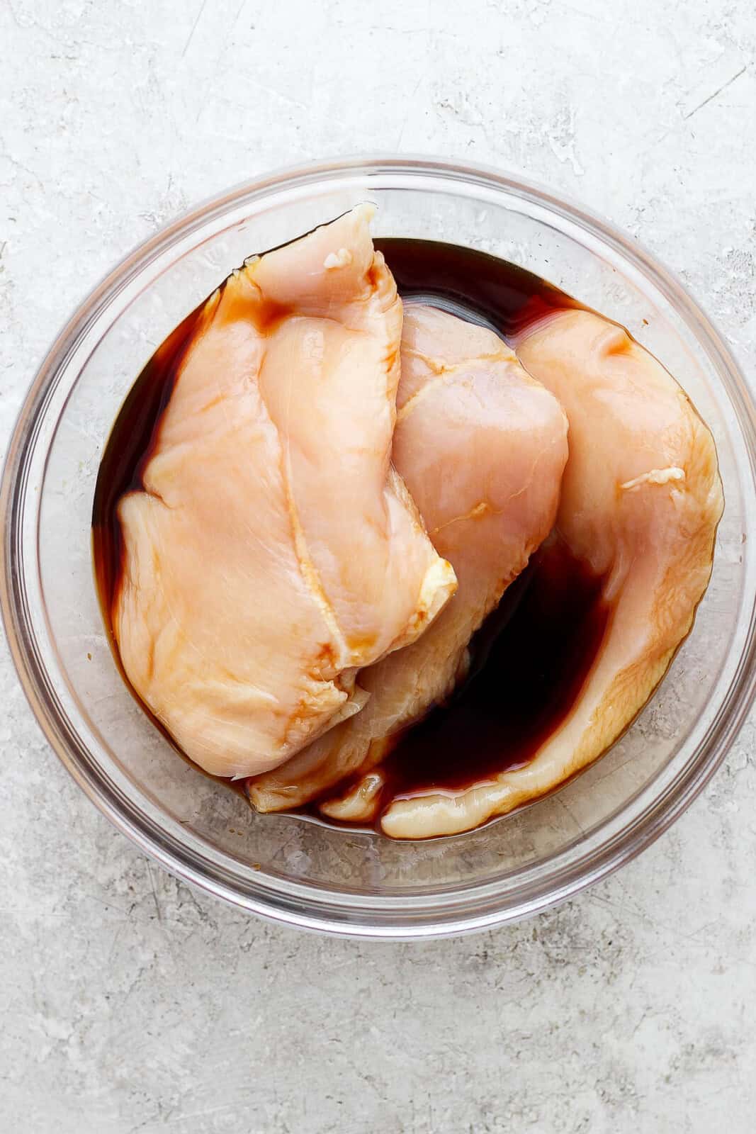 Chicken breasts marinating in soy sauce before being cooked to make bruschetta chicken pasta.