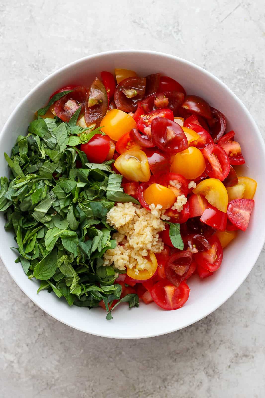 Bruschetta mixture in a white bowl before being mixed to make bruschetta chicken pasta.