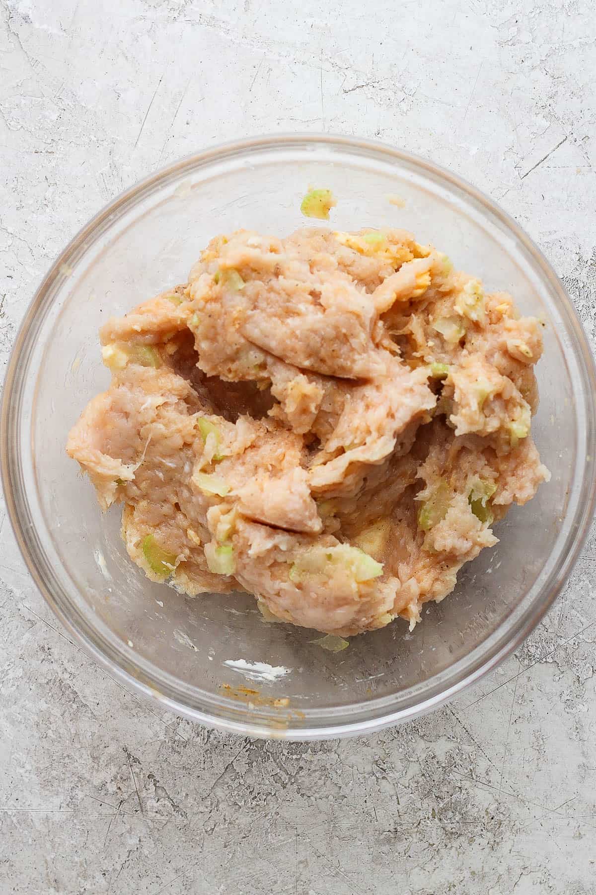 Buffalo Chicken Burgers - packed with flavor these burgers are a perfect weeknight dinner (and they make amazing leftovers!). GF + DF + Paleo + Whole30 #buffalochickenburger #buffalochicken #buffalochickenburgergrilled #buffalochickenburgerhealthy Buffalo chicken burger mixture fully combined in a glass bowl.