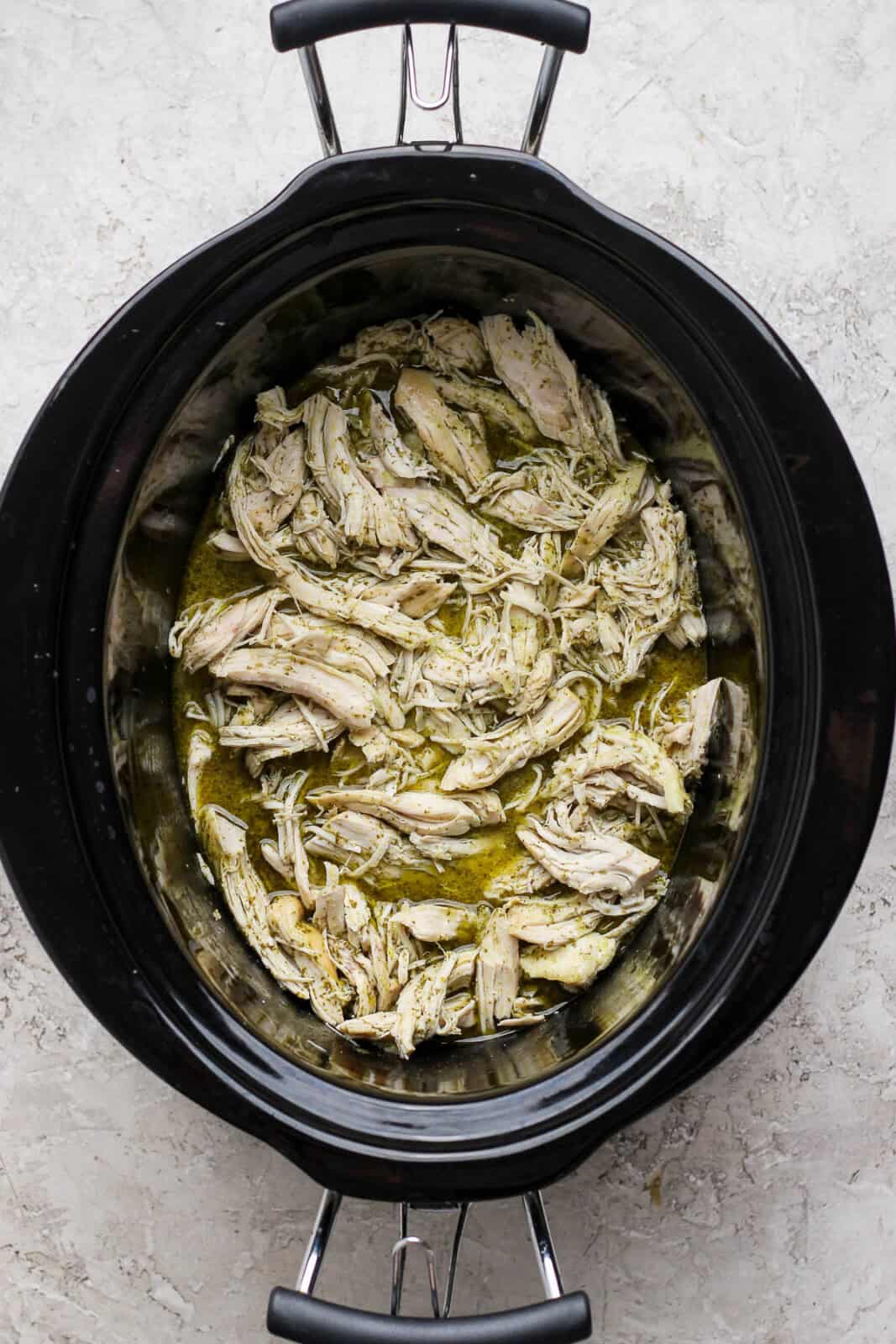 Crockpot cilantro lime chicken that is cooked, shredded, and returned to the crockpot.