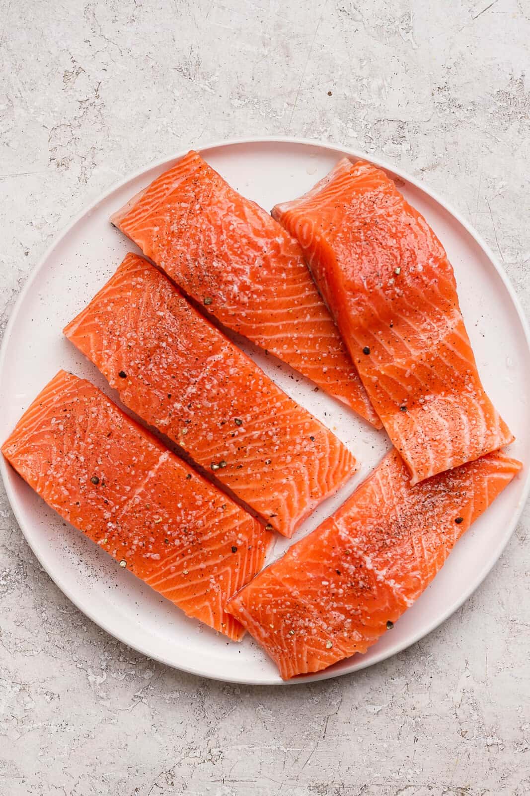 Grilled salmon fillets with salt and pepper before they go on the grill.