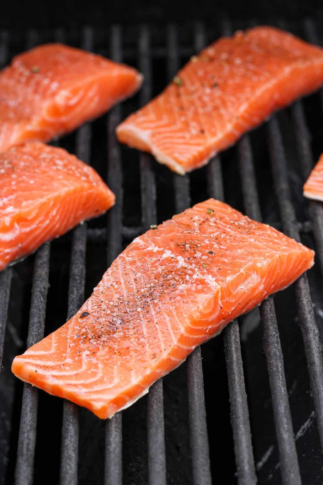 Salmon fillets placed on a hot grill.