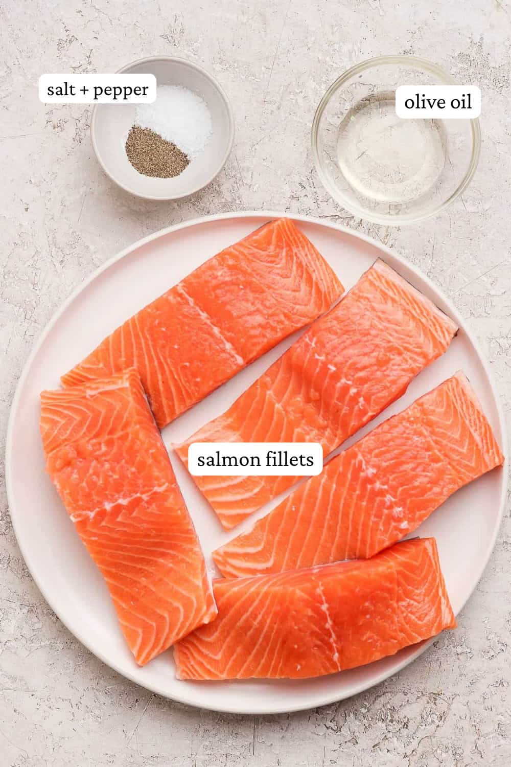 Ingredients for how to grill salmon on a plate and small bowls with labels.