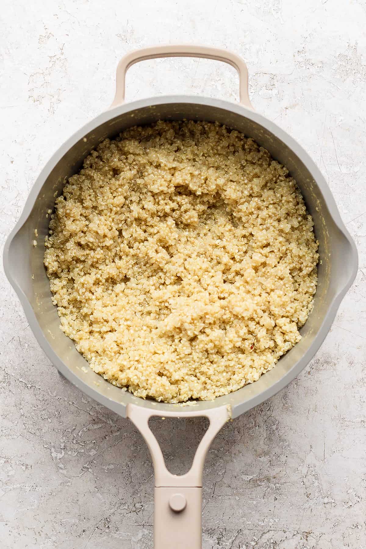 Cooked quinoa in a saucepan for making a Mediterranean chicken quinoa bowl.