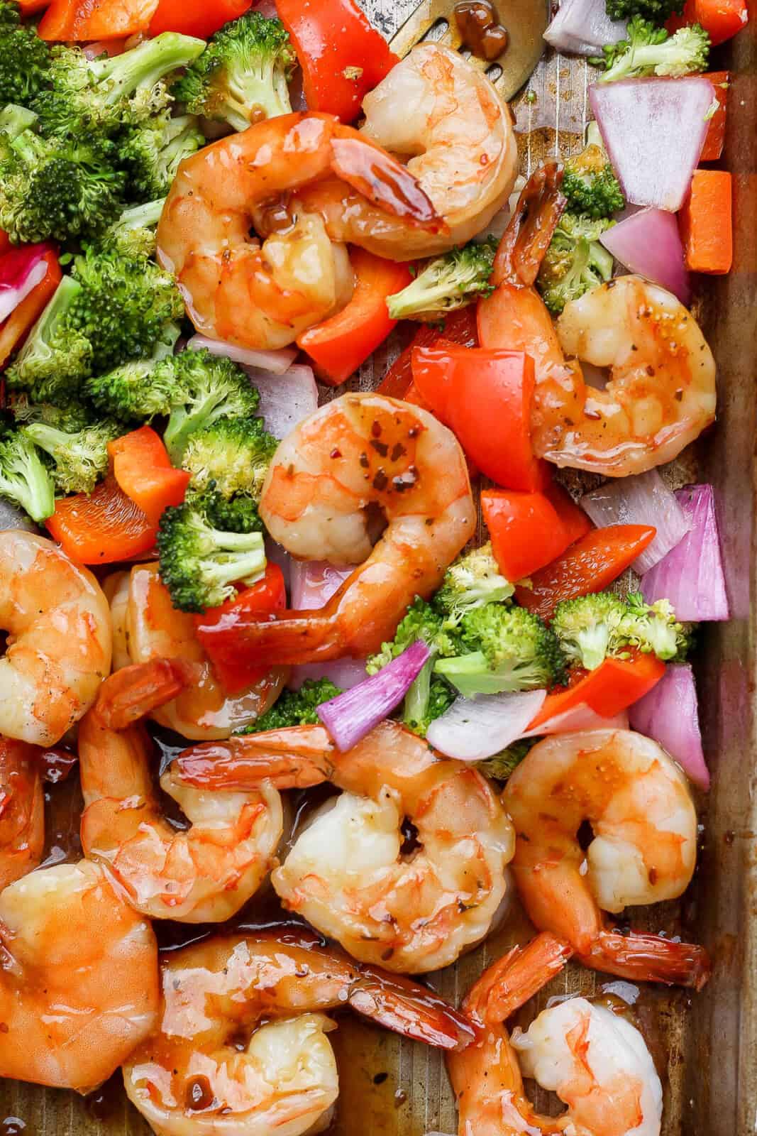 Teriyaki shrimp sheet pan dinner mixed together on a large sheet pan.