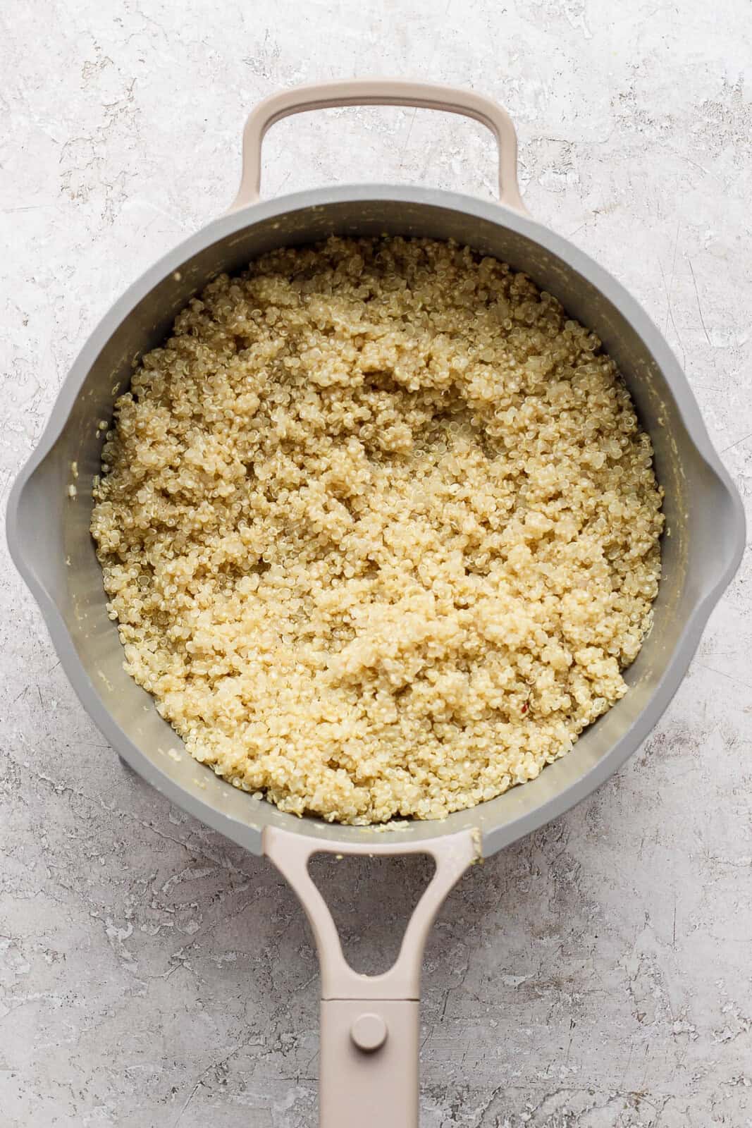 Cooked quinoa in a saucepan for summer quinoa salad bowls.