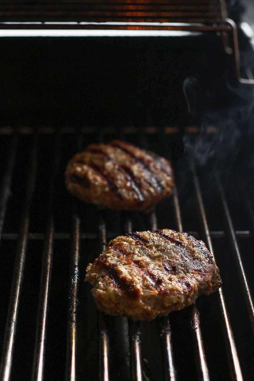 Avocado turkey burgers cooking on the grill.