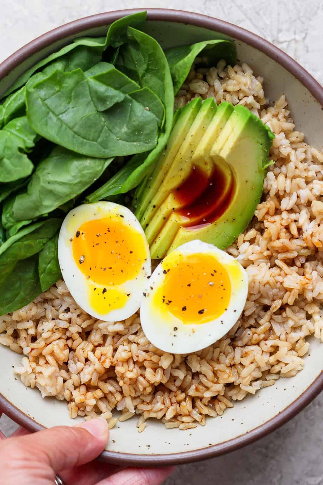 Someone holding a fully assembled avocado egg bowl.