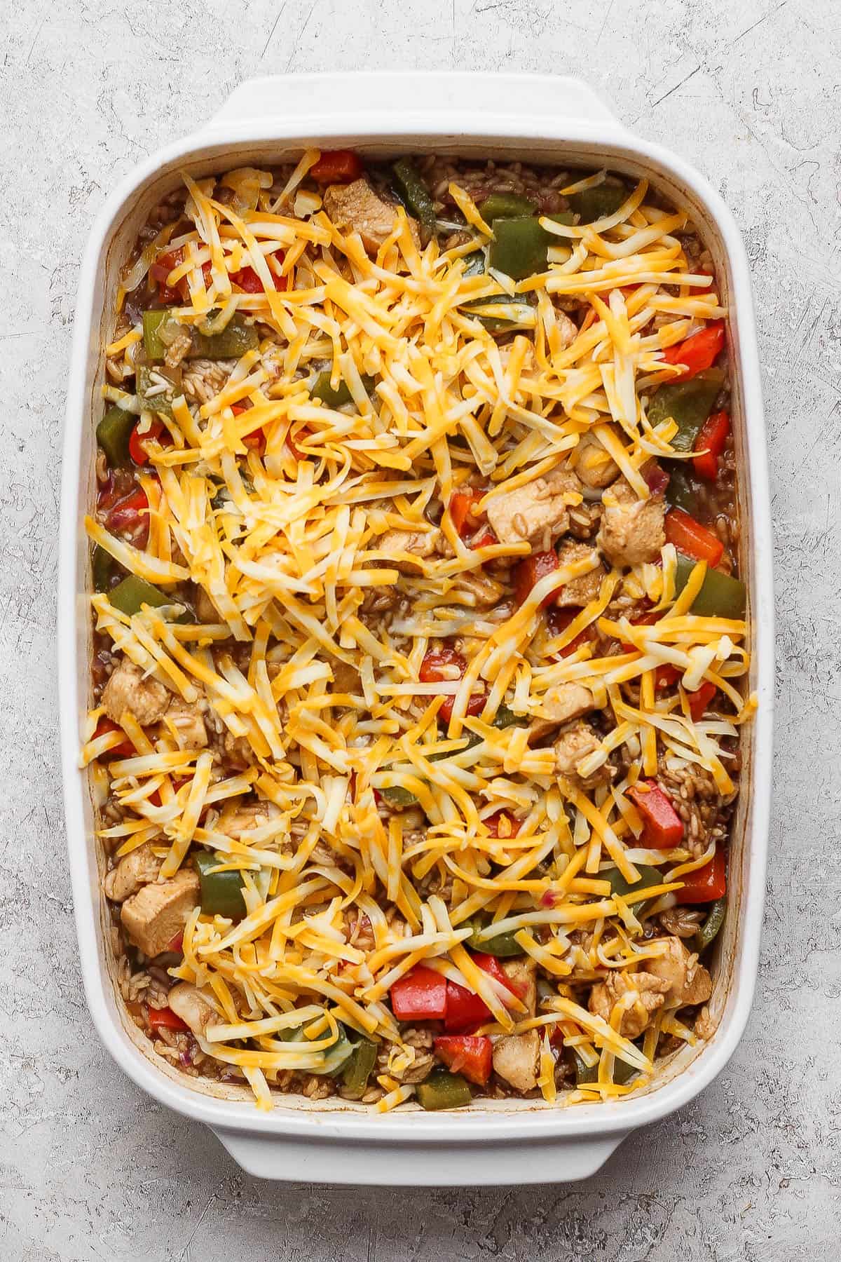 Baked chicken fajita casserole with rice with shredded cheese on top.