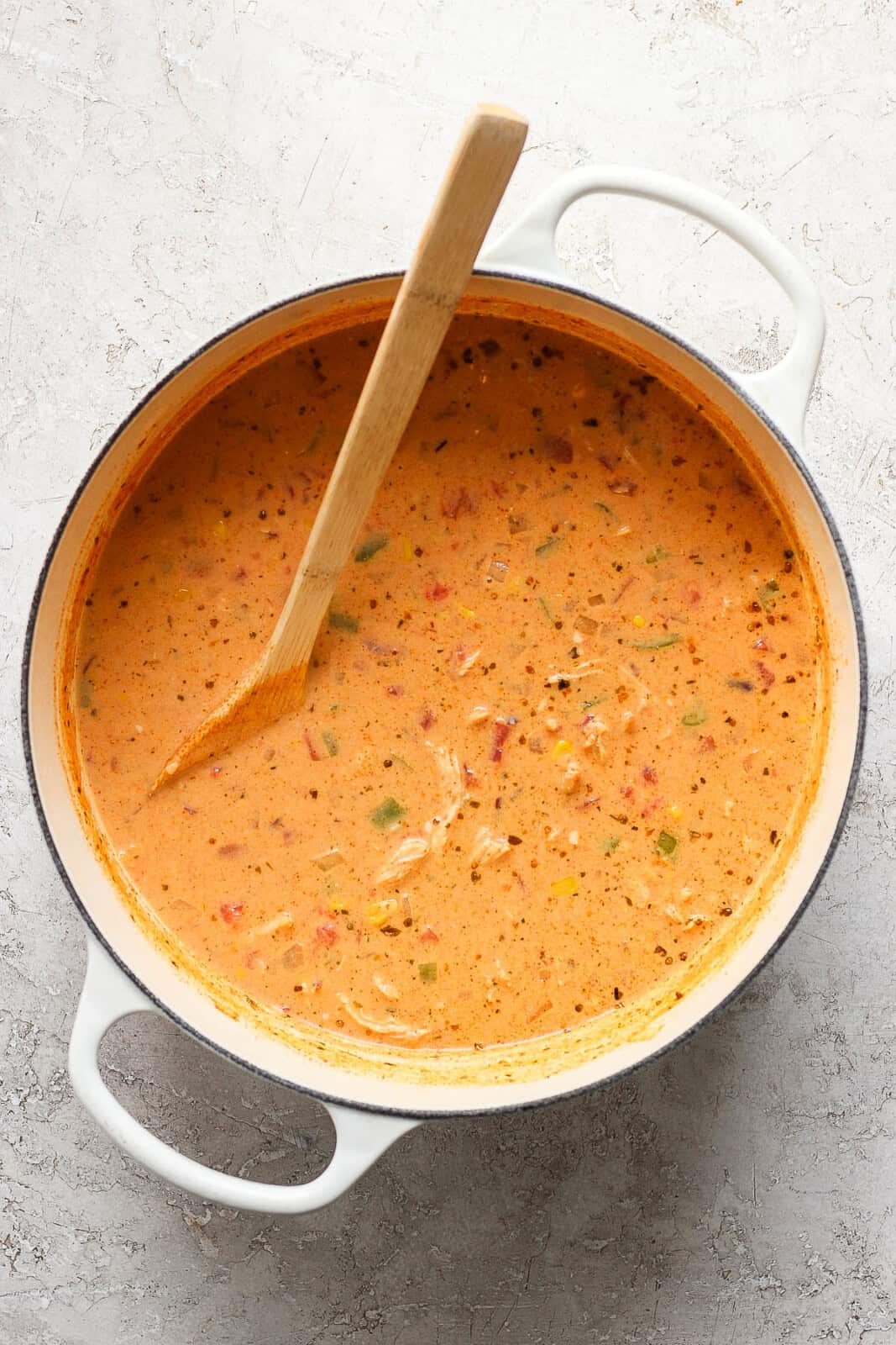 Chicken taco soup in a large pot with a wooden spoon.