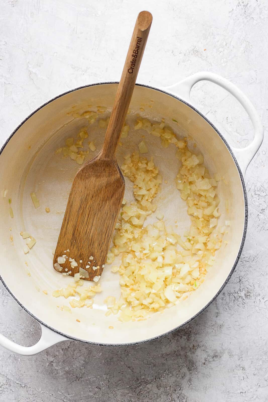 Diced onion and minced garlic sautéing in a pot for chicken taco soup.