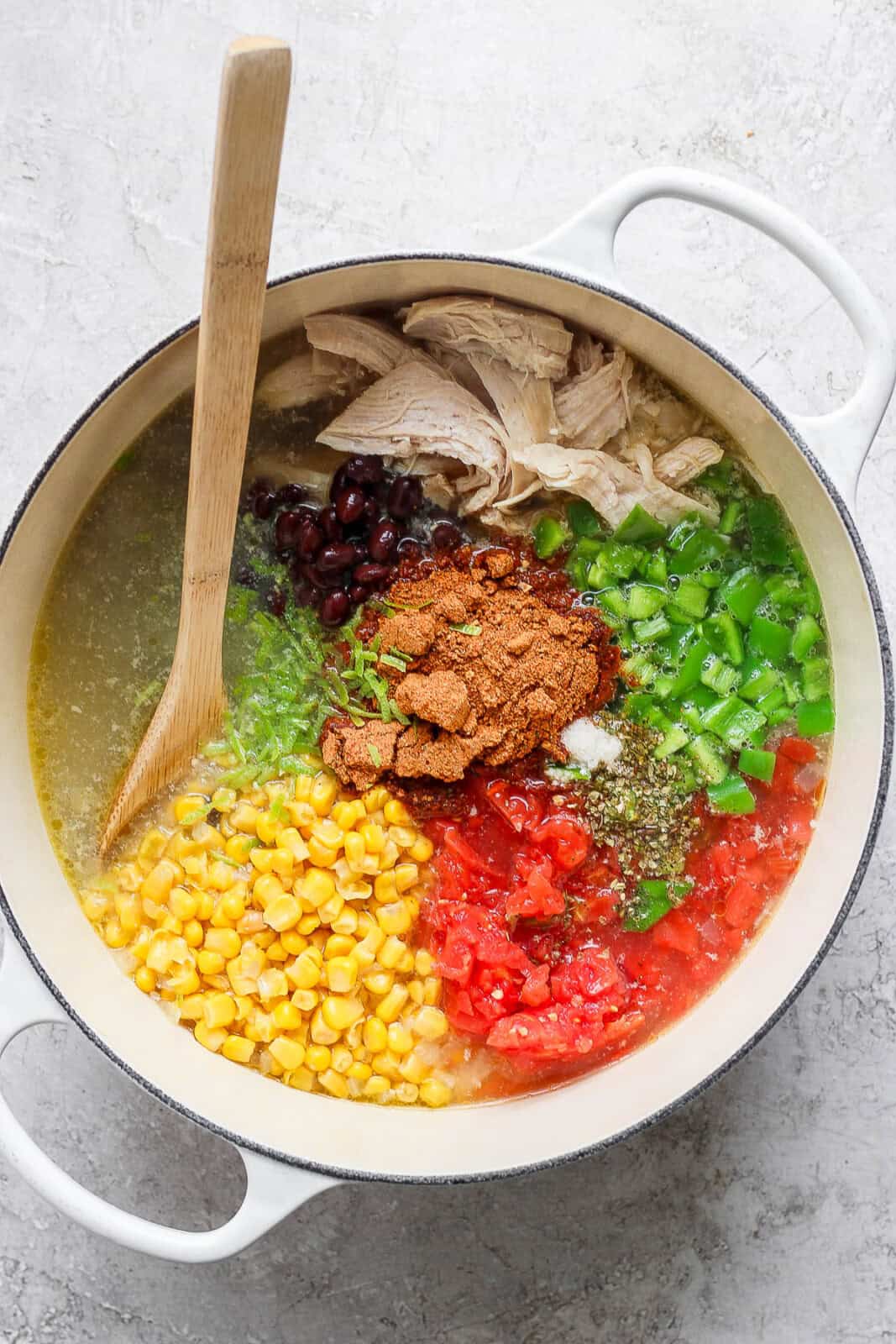 Chicken taco soup in a large pot before it is mixed together and before the cream cheese is added.