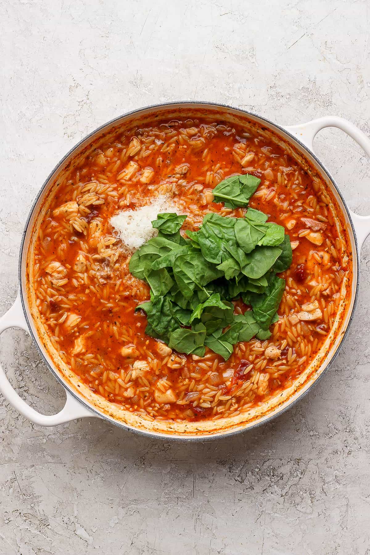 Spinach and parmesan cheese added to marry me chicken orzo skillet.
