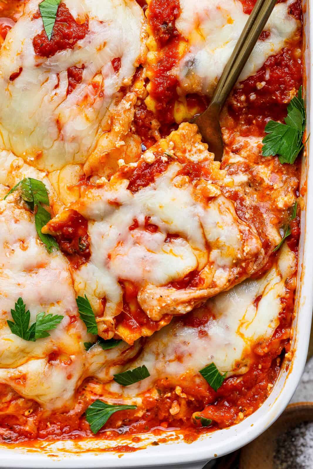 Fully baked million dollar ravioli casserole with a fork stuck into it.