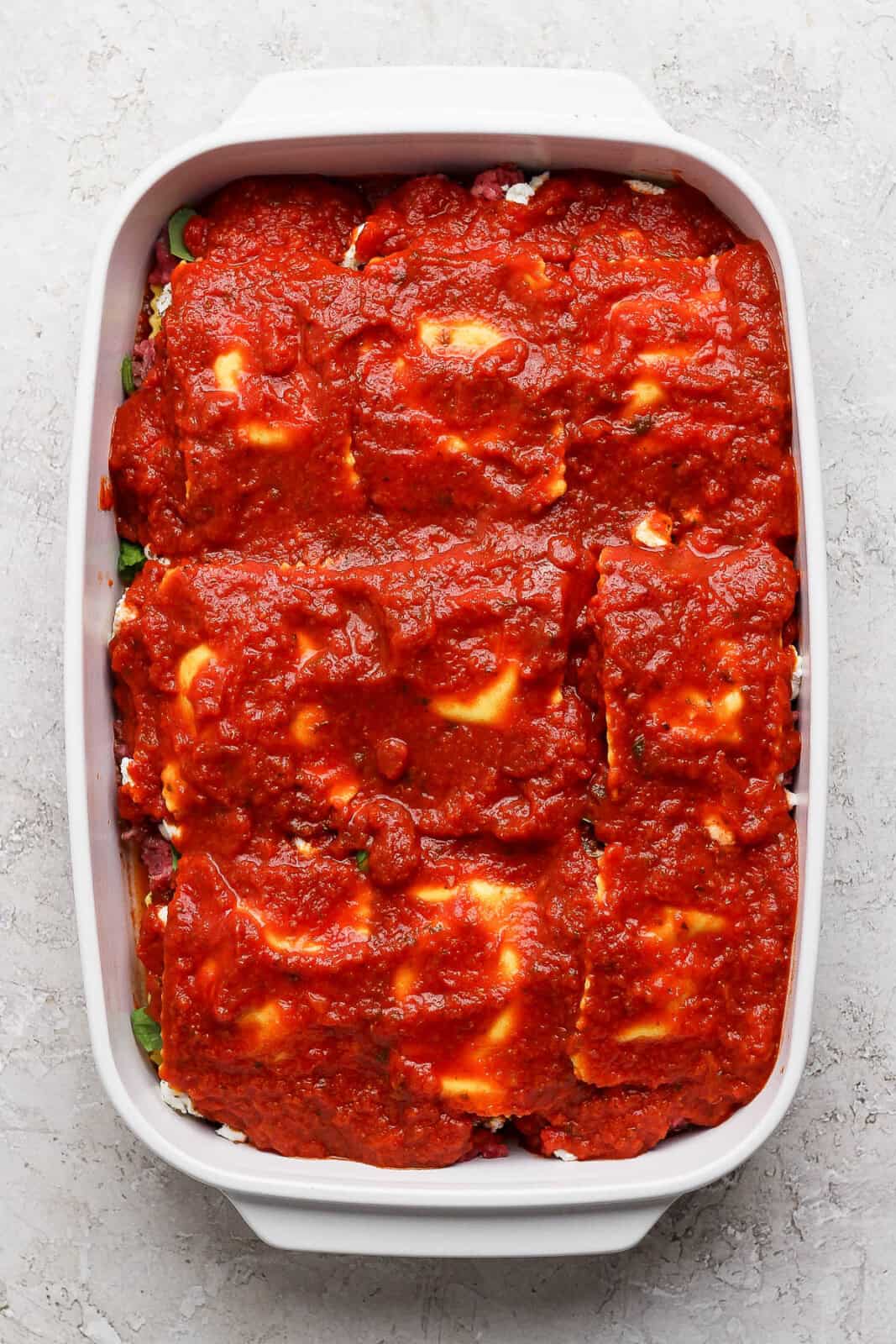 A fully assembled million dollar ravioli casserole before baking.