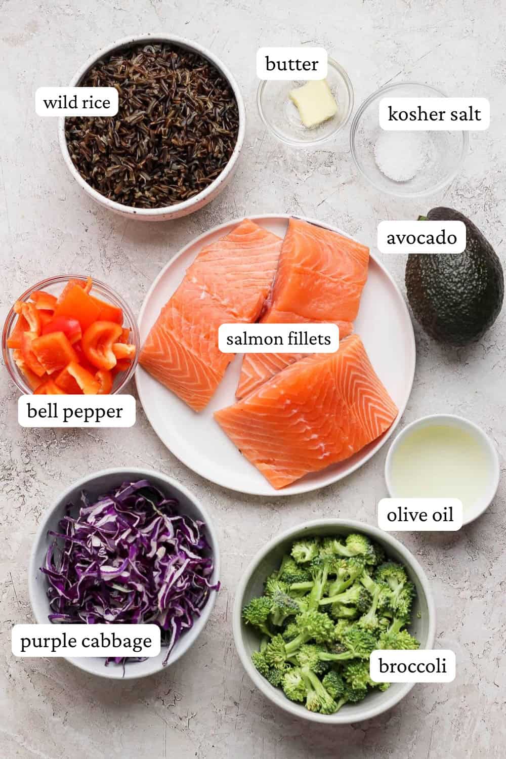 Salmon power bowl ingredients on a plate and in small bowls with labels.