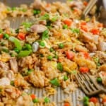 Sheet pan fried rice fully cooked on the sheet pan with two forks.