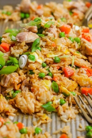 Sheet pan fried rice fully cooked on the sheet pan with two forks.