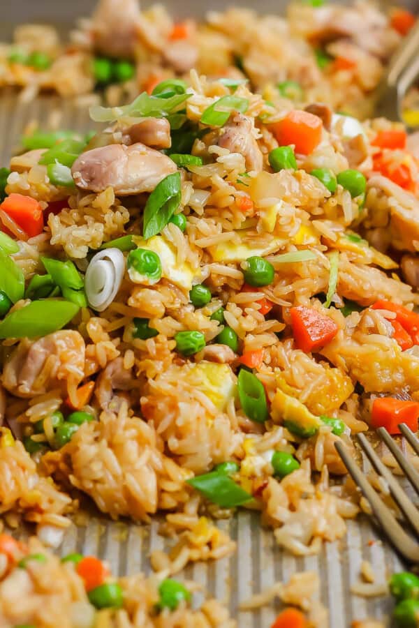 Sheet pan fried rice fully cooked on the sheet pan with two forks.