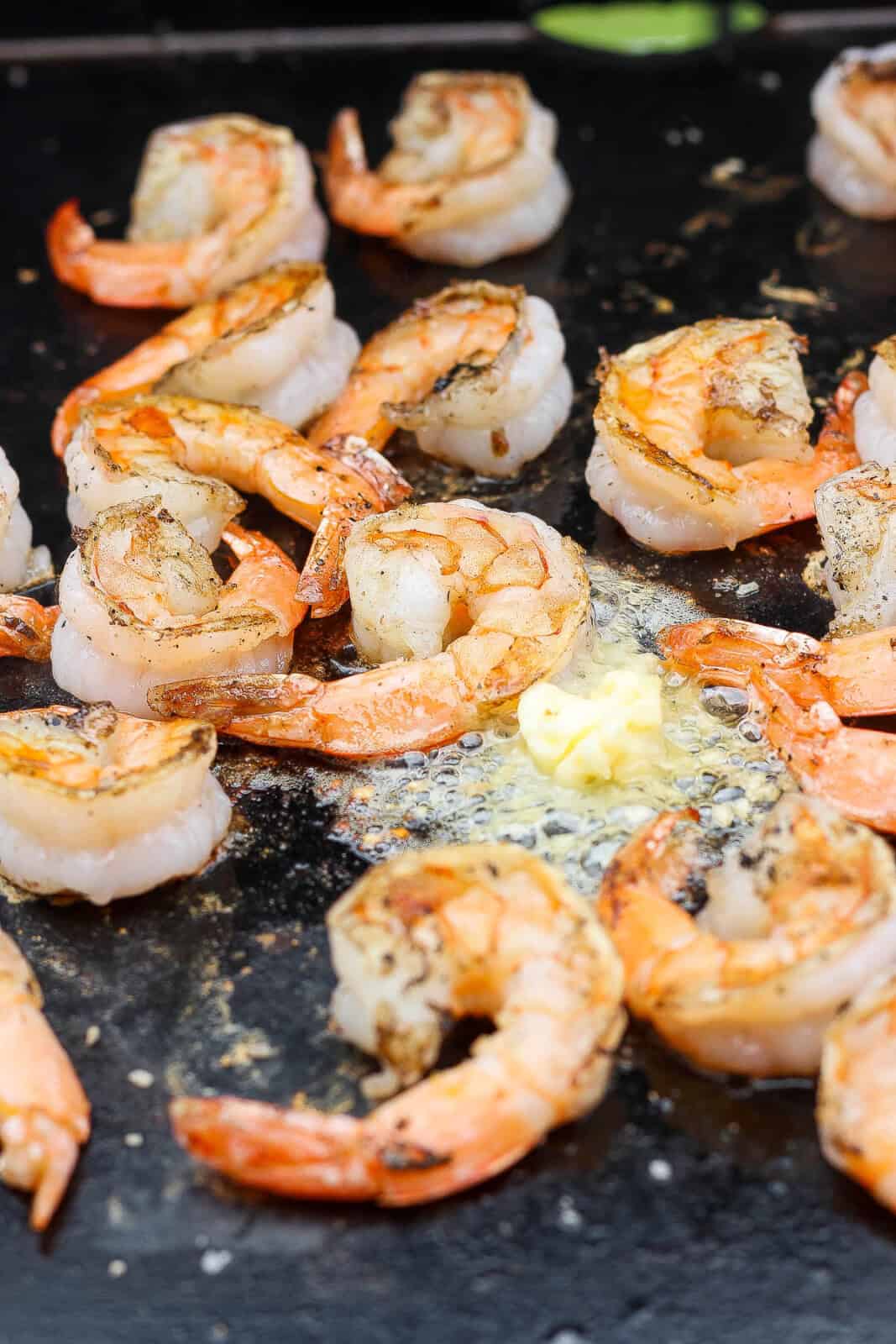 Shrimp on the Blackstone cooking with garlic butter.