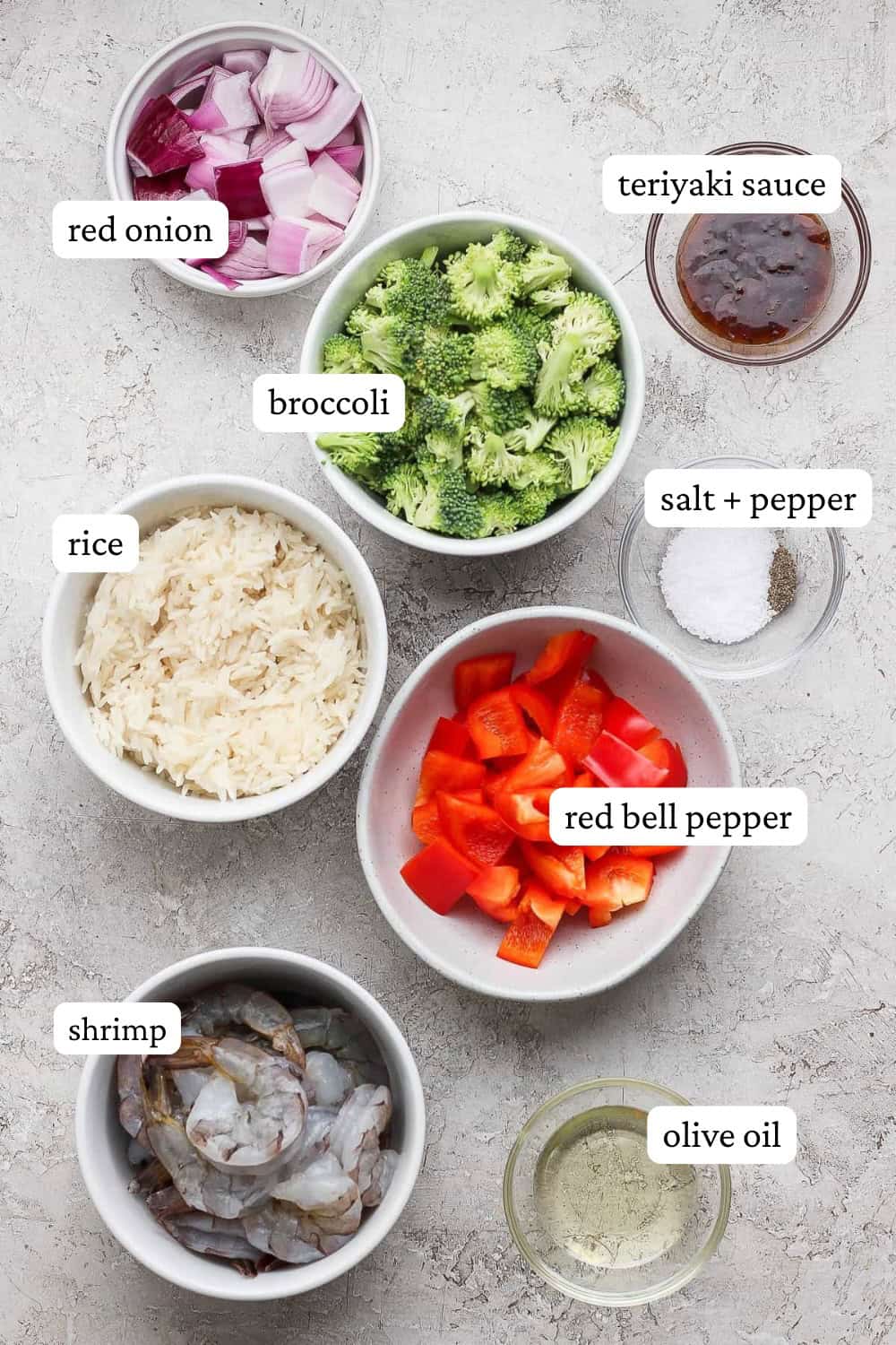 Shrimp sheet pan dinner ingredients in separate bowls with labels.